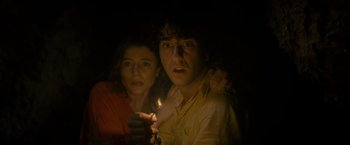 Movie still from “Old” (2021), directed by M. Night Shyamalan – A man and a woman holding a candle in a dark room; Close Up shot, Low angle