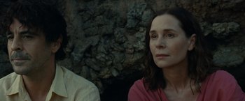 Movie still from “Old” (2021), directed by M. Night Shyamalan – A woman sitting next to a man in front of a rock wall; Close Up shot, High angle