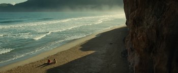 Movie still from “Old” (2021), directed by M. Night Shyamalan – A person standing on a beach near the ocean; Extreme Wide shot, High angle