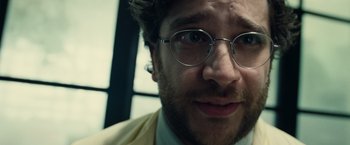 Movie still from “Old” (2021), directed by M. Night Shyamalan – A person wearing glasses and a suit; Close Up shot, Low angle