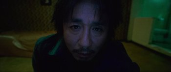 Movie still from “Oldboy” (2003), directed by Park Chan-wook – A person's face in the dark; Extreme Close Up shot, Overhead angle