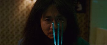Movie still from “Oldboy” (2003), directed by Park Chan-wook – A woman with long black hair holding a pair of blue straws; Close Up shot, Low angle