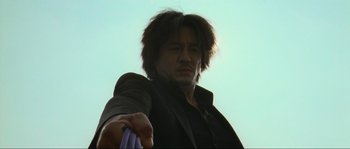 Movie still from “Oldboy” (2003), directed by Park Chan-wook – A man with long hair is holding something in his hand; Close Up shot, Low angle