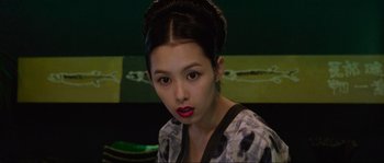 Movie still from “Oldboy” (2003), directed by Park Chan-wook – A young woman with dark brown hair wearing a black and white dress; Close Up shot, Over the shoulder angle