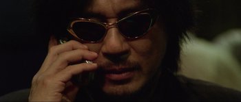 Movie still from “Oldboy” (2003), directed by Park Chan-wook – A person talking on a cell phone; Extreme Close Up shot, Low angle
