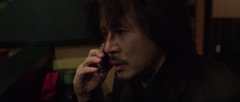 Movie still from “Oldboy” (2003), directed by Park Chan-wook – A man is talking on a cell phone; Close Up shot, Low angle