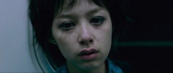 Movie still from “Oldboy” (2003), directed by Park Chan-wook – A person with a sad look on their face; Close Up shot, Overhead angle