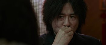 Movie still from “Oldboy” (2003), directed by Park Chan-wook – A person with his hand to his face; Close Up shot, Over the shoulder angle