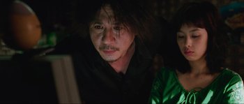 Movie still from “Oldboy” (2003), directed by Park Chan-wook – A man in a black shirt is looking at the camera; Close Up shot, Over the shoulder angle