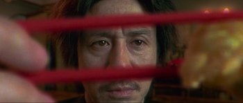 Movie still from “Oldboy” (2003), directed by Park Chan-wook – A person behind a red fence; Extreme Close Up shot, Low angle