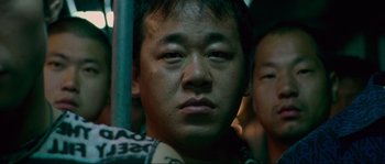 Movie still from “Oldboy” (2003), directed by Park Chan-wook – A man's face in a crowded bus; Close Up shot, Low angle