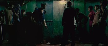 Movie still from “Oldboy” (2003), directed by Park Chan-wook – A group of people standing around a room; Wide shot, High angle
