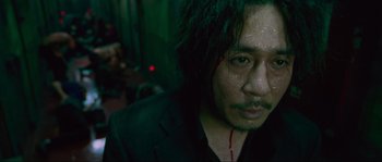 Movie still from “Oldboy” (2003), directed by Park Chan-wook – A person wearing a suit and tie; Close Up shot, High angle