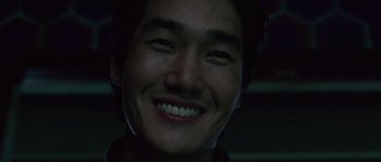 Movie still from “Oldboy” (2003), directed by Park Chan-wook – A person smiling for the camera; Close Up shot, Low angle