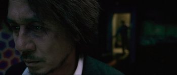 Movie still from “Oldboy” (2003), directed by Park Chan-wook – A man in a green jacket and a black hat; Extreme Close Up shot, Over the shoulder angle