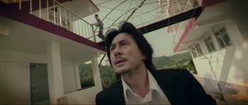 Movie still from “Oldboy” (2003), directed by Park Chan-wook – A man in a suit looking up into the sky; Medium shot, Low angle