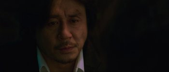 Movie still from “Oldboy” (2003), directed by Park Chan-wook – A person wearing a suit and tie; Close Up shot, Over the shoulder angle