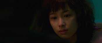 Movie still from “Oldboy” (2003), directed by Park Chan-wook – A young woman with a dark background looking at the camera; Close Up shot, Over the shoulder angle