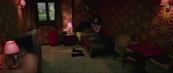 Movie still from “Oldboy” (2003), directed by Park Chan-wook – A woman sitting on a bed in front of a television; Wide shot, High angle