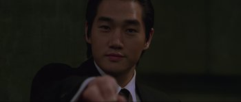 Movie still from “Oldboy” (2003), directed by Park Chan-wook – A man in a suit and tie pointing at the camera; Close Up shot, Low angle