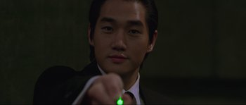 Movie still from “Oldboy” (2003), directed by Park Chan-wook – A man in a suit holding a green light; Close Up shot, High angle