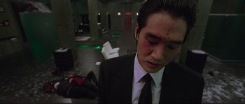 Movie still from “Oldboy” (2003), directed by Park Chan-wook – A man in a black suit with blood all over his face; Medium shot, High angle