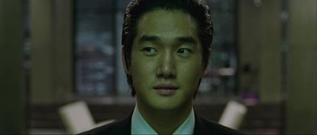 Movie still from “Oldboy” (2003), directed by Park Chan-wook – A person wearing a suit and tie; Close Up shot, High angle