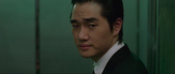 Movie still from “Oldboy” (2003), directed by Park Chan-wook – A person wearing a suit and tie; Close Up shot, Low angle