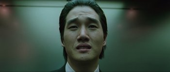 Movie still from “Oldboy” (2003), directed by Park Chan-wook – A person wearing a suit and tie; Close Up shot, Low angle