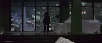 Movie still from “Oldboy” (2003), directed by Park Chan-wook – A man standing in front of a window at night; Extreme Wide shot, High angle