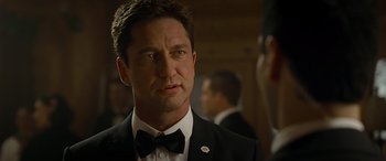 Movie still from “Olympus Has Fallen” (2013), directed by Antoine Fuqua – A man in a suit and bow tie; Close Up shot, Over the shoulder angle