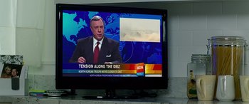 Movie still from “Olympus Has Fallen” (2013), directed by Antoine Fuqua – A television screen with a news anchor on it; Close Up shot, Over the shoulder angle