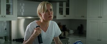 Movie still from “Olympus Has Fallen” (2013), directed by Antoine Fuqua – A woman holding a remote control in her hand; Close Up shot, Over the shoulder angle