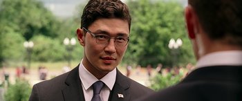 Movie still from “Olympus Has Fallen” (2013), directed by Antoine Fuqua – A man in a suit and tie wearing glasses; Close Up shot, Over the shoulder angle