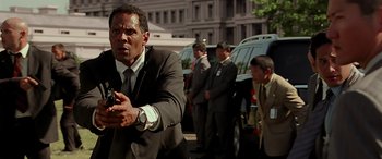 Movie still from “Olympus Has Fallen” (2013), directed by Antoine Fuqua – A man in a suit and tie holding a cell phone; Close Up shot, Low angle