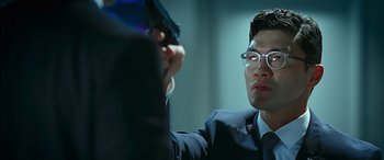 Movie still from “Olympus Has Fallen” (2013), directed by Antoine Fuqua – A man in a suit holding a gun in his hand; Close Up shot, Over the shoulder angle