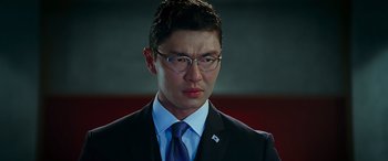 Movie still from “Olympus Has Fallen” (2013), directed by Antoine Fuqua – A man in a suit and tie wearing glasses; Close Up shot, Low angle