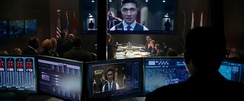 Movie still from “Olympus Has Fallen” (2013), directed by Antoine Fuqua – A group of people sitting in front of a television; Medium shot, Over the shoulder angle