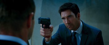 Movie still from “Olympus Has Fallen” (2013), directed by Antoine Fuqua – A man in a suit and tie holding a gun in front of a mirror; Close Up shot, Over the shoulder angle