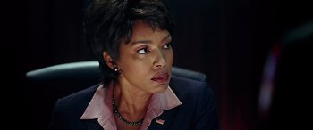 Movie still from “Olympus Has Fallen” (2013), directed by Antoine Fuqua – A person sitting in a chair wearing a suit; Close Up shot, Over the shoulder angle