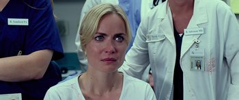 Movie still from “Olympus Has Fallen” (2013), directed by Antoine Fuqua – A woman in a white lab coat looking at the camera; Close Up shot, Over the shoulder angle