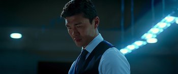 Movie still from “Olympus Has Fallen” (2013), directed by Antoine Fuqua – A man wearing a suit and tie standing in the dark; Close Up shot, Low angle