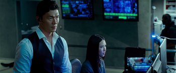 Movie still from “Olympus Has Fallen” (2013), directed by Antoine Fuqua – A man and a woman sitting next to each other in front of monitors; Medium shot, Over the shoulder angle