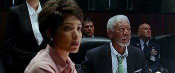Movie still from “Olympus Has Fallen” (2013), directed by Antoine Fuqua – A woman and two men in suits and ties sitting in a courtroom; Medium shot, Over the shoulder angle