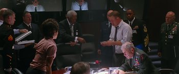 Movie still from “Olympus Has Fallen” (2013), directed by Antoine Fuqua – A group of people sitting around a conference room; Medium shot, Over the shoulder angle