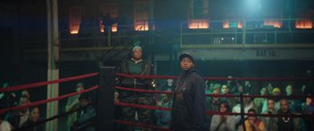 Movie still from “On the Come Up” (2022), directed by Sanaa Lathan – Two people standing in a boxing ring in front of a crowd of onlookers; Wide shot, Over the shoulder angle