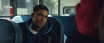Movie still from “On the Come Up” (2022), directed by Sanaa Lathan – A young man sitting on a bus wearing headphones; Close Up shot, Over the shoulder angle