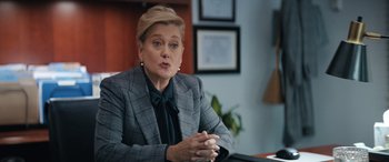 Movie still from “On the Come Up” (2022), directed by Sanaa Lathan – A woman wearing a suit and tie sitting at a desk; Medium shot, Over the shoulder angle