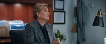 Movie still from “On the Come Up” (2022), directed by Sanaa Lathan – A woman wearing a suit and tie sitting in front of a window; Medium shot, Over the shoulder angle