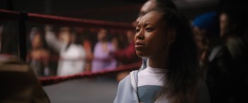 Movie still from “On the Come Up” (2022), directed by Sanaa Lathan – A young woman standing in front of a boxing ring; Close Up shot, Over the shoulder angle
